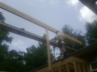 Carpenter setting a ridge beam over a new addition frame — Ice Dam Removal by Roofing Brothers in Napavine